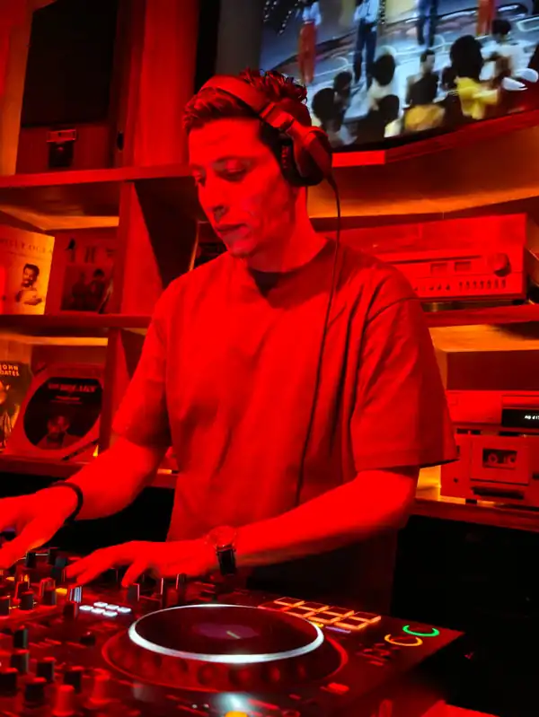 Le DJ aux platines sous la lumière rouge